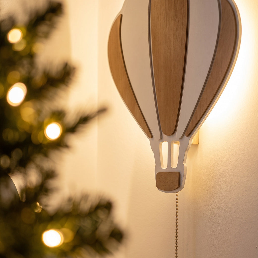 La montgolfière allumée au mur, près d'un sapin de Noël.